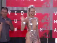 Scantily clad Miley Cyrus poses for photographers